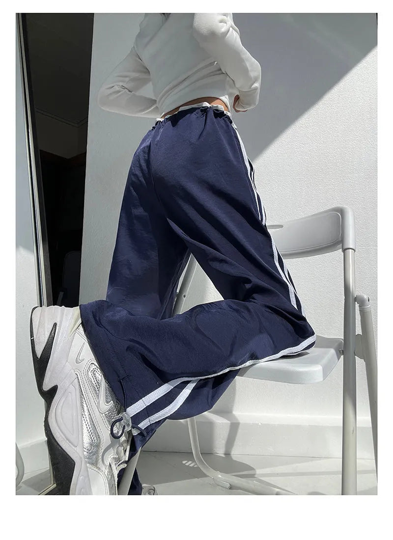 Women's navy blue straight leg trousers with a low waist and slimming drape.