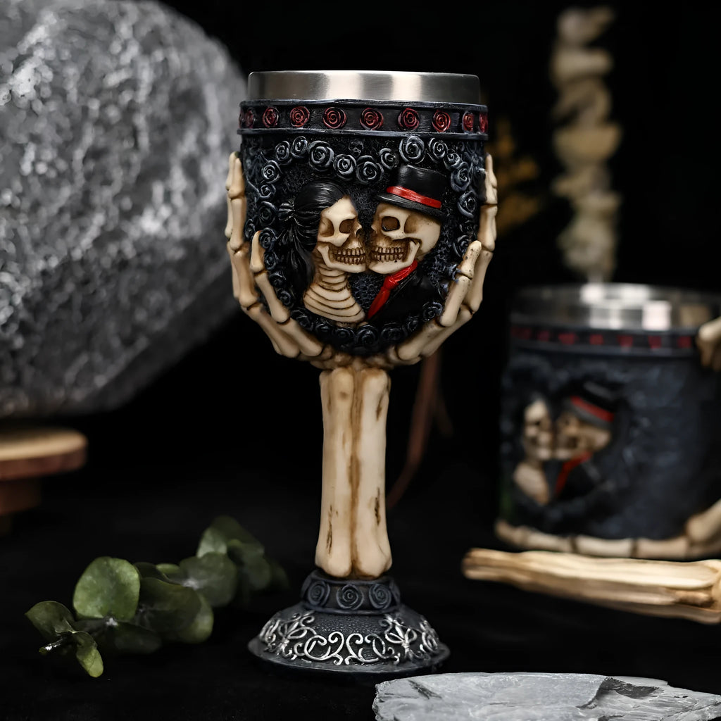 A pair of stainless steel wine glasses with a detailed red human skeleton pattern on a black background.