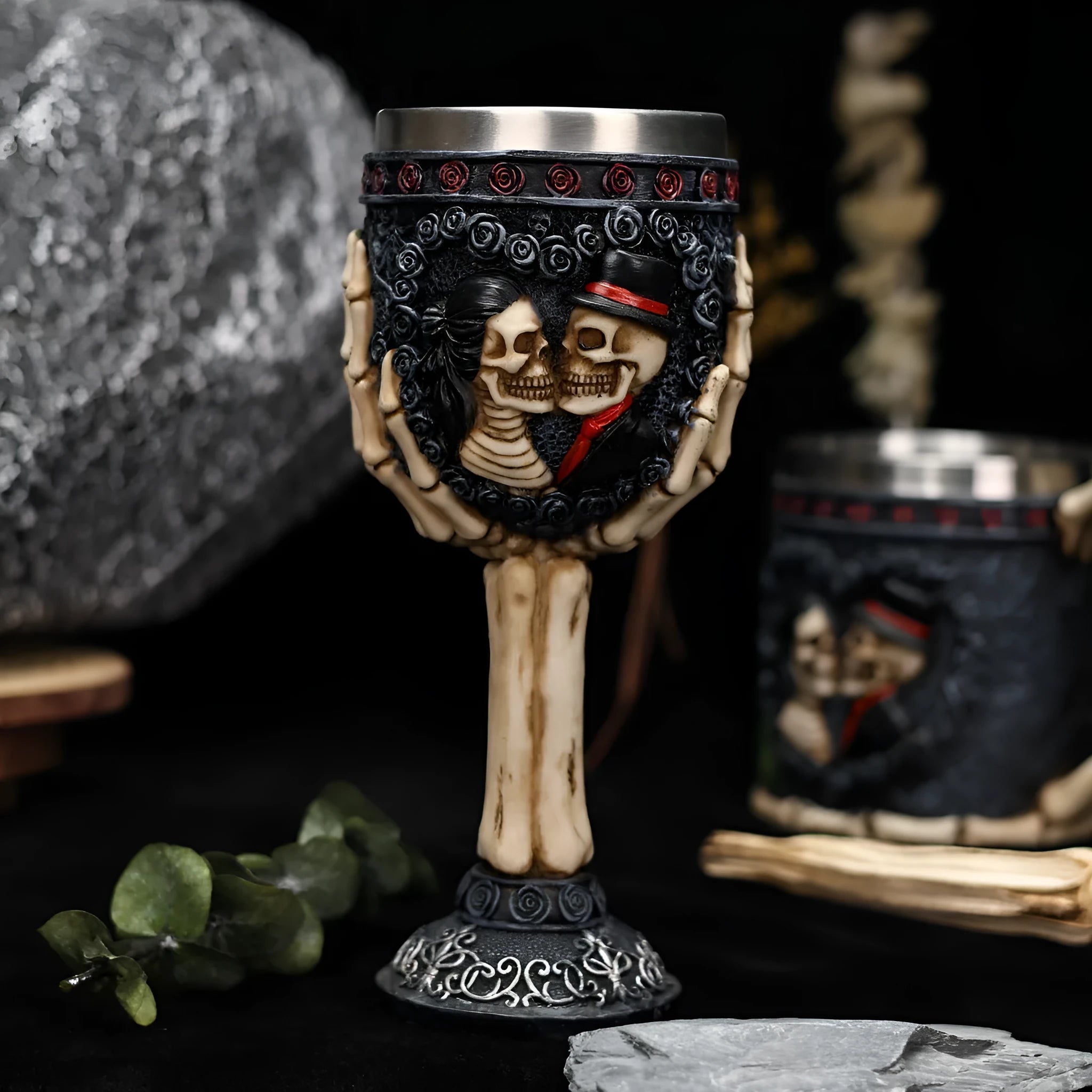 A pair of stainless steel wine glasses with a detailed red human skeleton pattern on a black background.