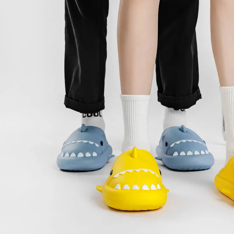 Winter soft bottom household couple EVA cartoon shark cotton slippers in blue, grey, pink on a floor