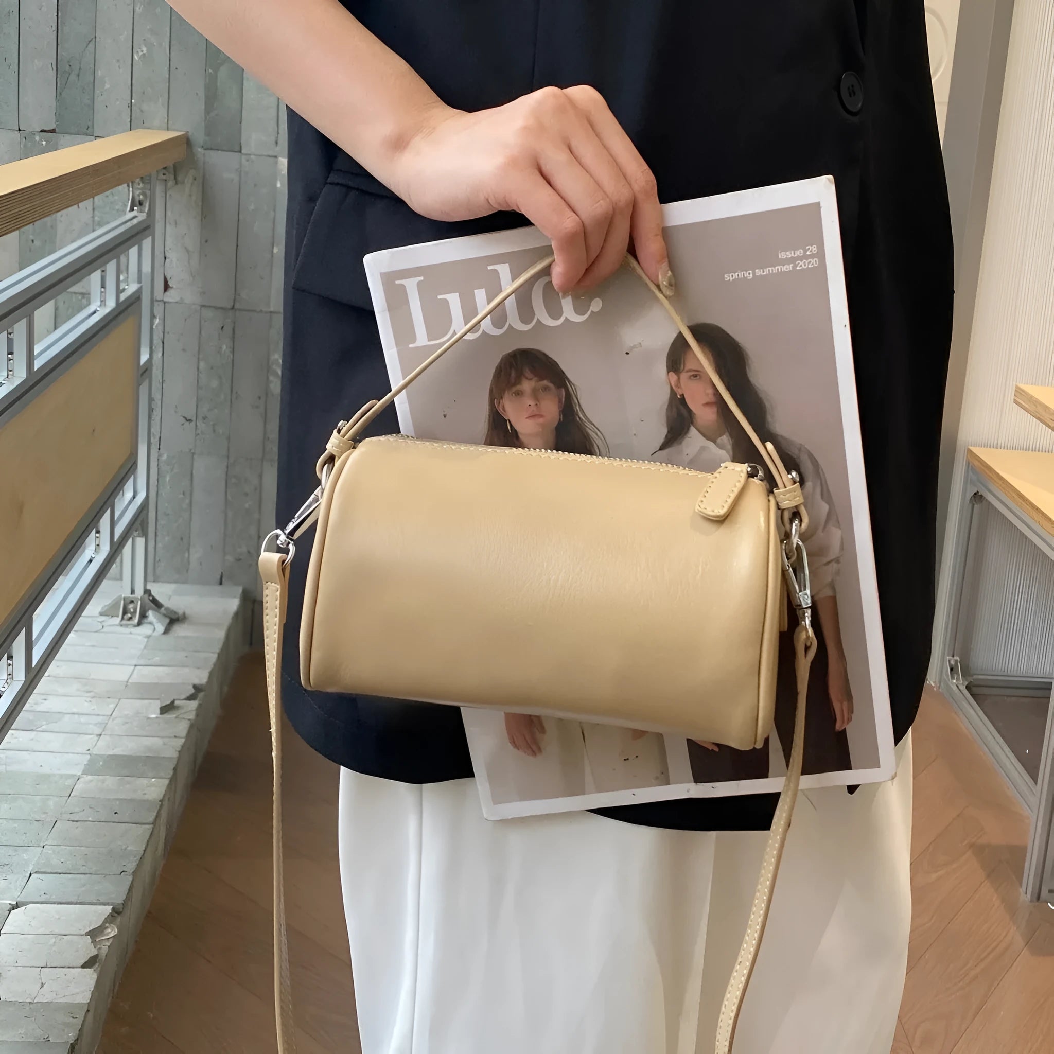 Soft brown genuine leather cylindrical crossbody phone bag with adjustable strap.