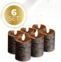 Black S6 LED pillar candle with glowing flickering flame effect on a table.