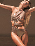 Women's gold one-piece backless swimsuit made from spandex, shown on a model.