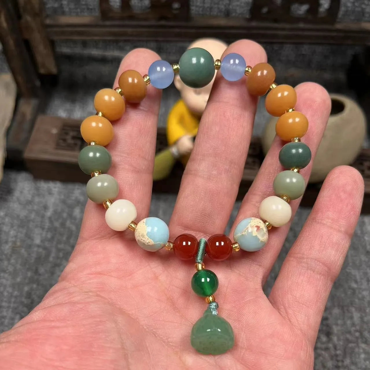 Carved Bodhi root bracelet with white jade, lotus, and pumpkin beads in various sizes.