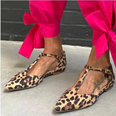 Leopard print women's pumps with a pointed toe, cross straps, and a low chunky heel on a rubber sole.