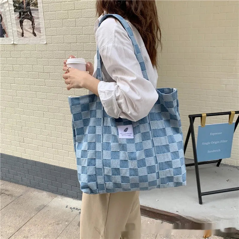 Large pink women's canvas shoulder bag with a textured three-dimensional front pocket.