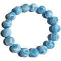 Blue handmade bodhi bracelet with natural sea-pattern crystal beads and pearl details on a wrist.