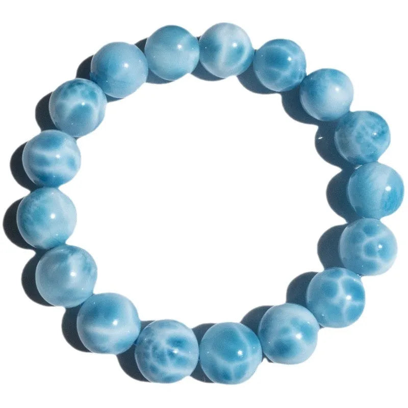 Blue handmade bodhi bracelet with natural sea-pattern crystal beads and pearl details on a wrist.