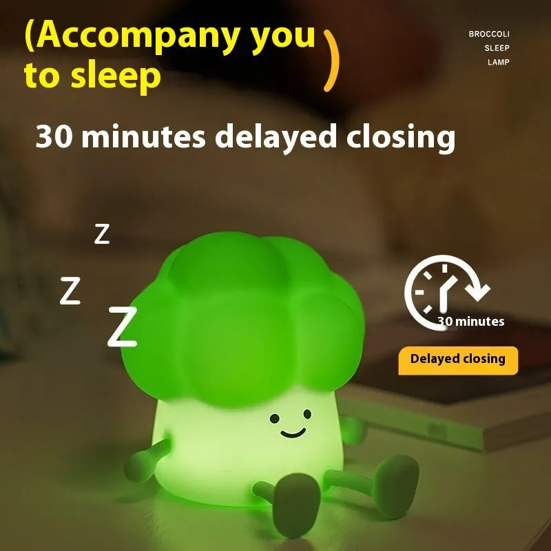 Cartoon eggplant-shaped small night lamp with soft yellow glow, shown next to a broccoli design variant.