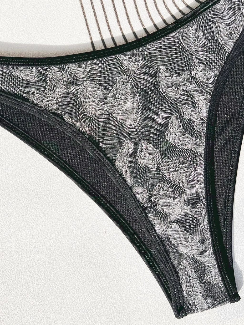 Black strapless one-piece ladies swimsuit on a hanger.