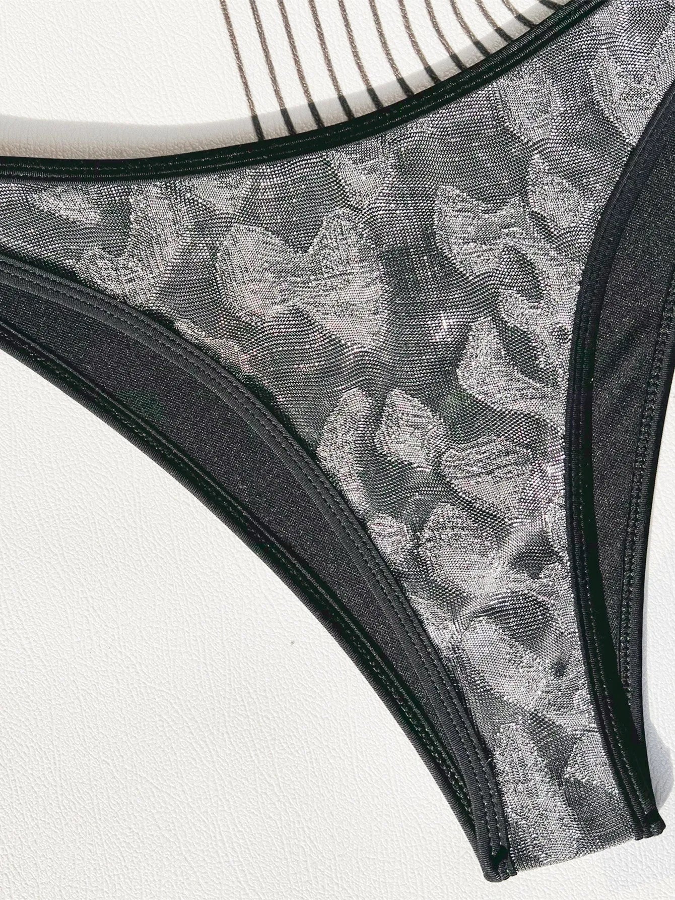 Black strapless one-piece ladies swimsuit on a hanger.