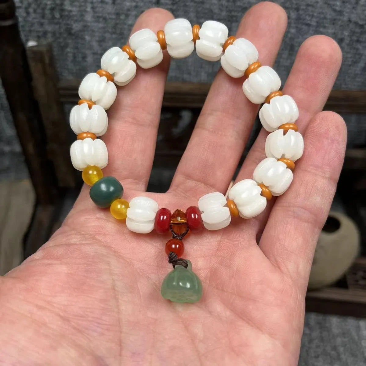 Carved Bodhi root bracelet with white jade, lotus, and pumpkin beads in various sizes.