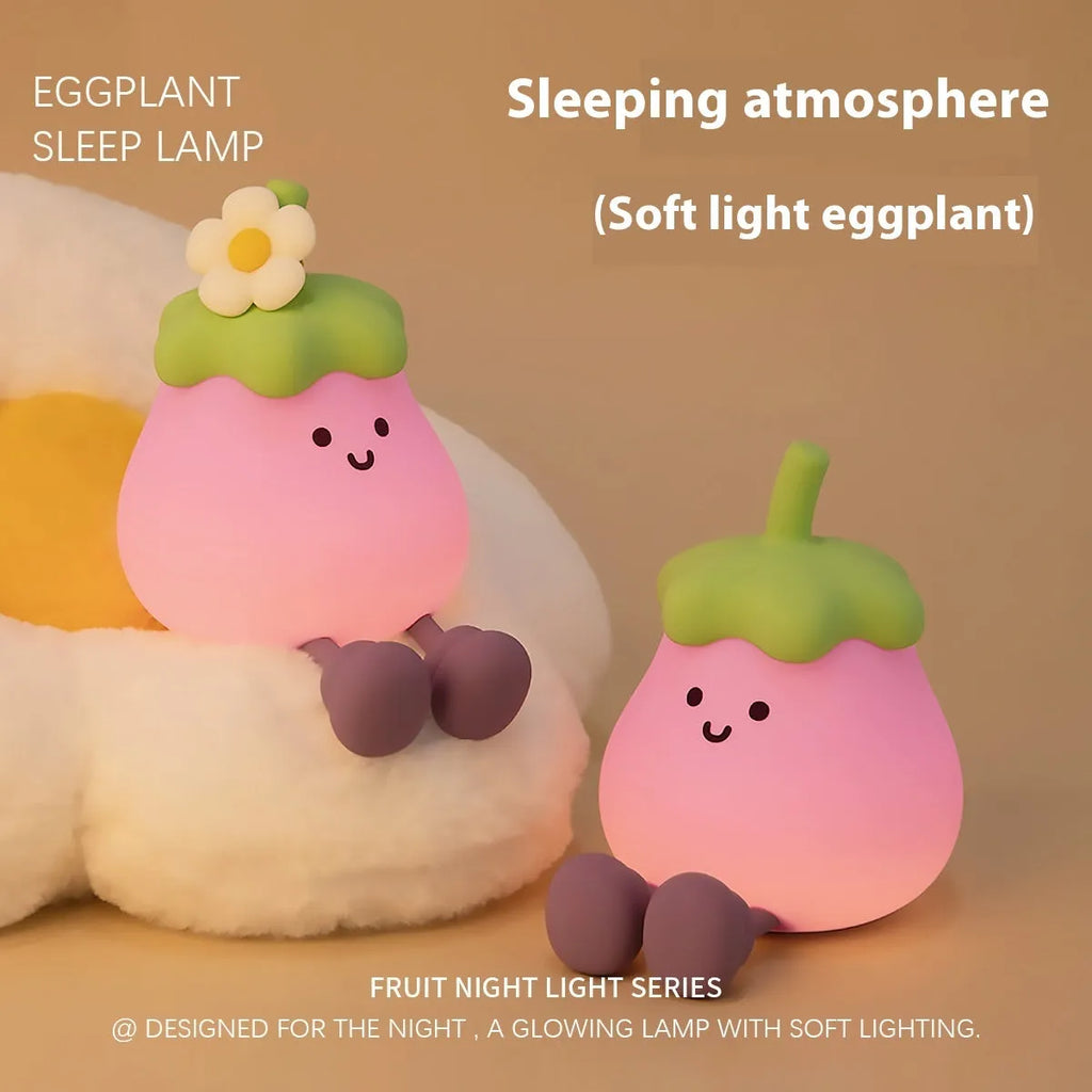 Cartoon eggplant-shaped small night lamp with soft yellow glow, shown next to a broccoli design variant.