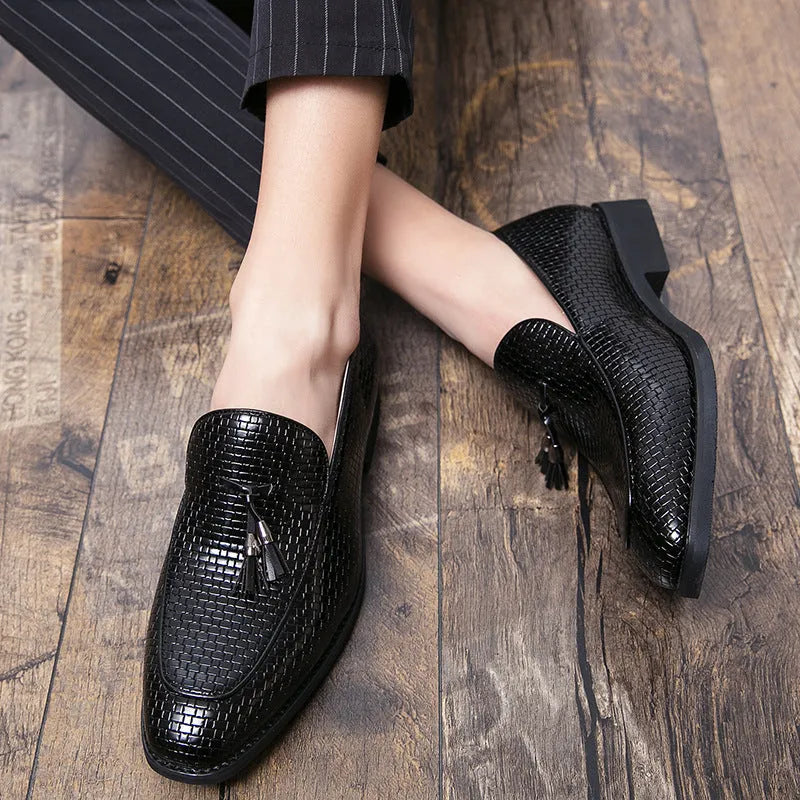 Men's black pointed-toe slip on shoes with a tassel detail on the low-top PU upper.