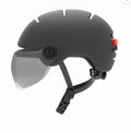Cycling helmet with integrated red LED brake light on the back, shown in PC shell construction.