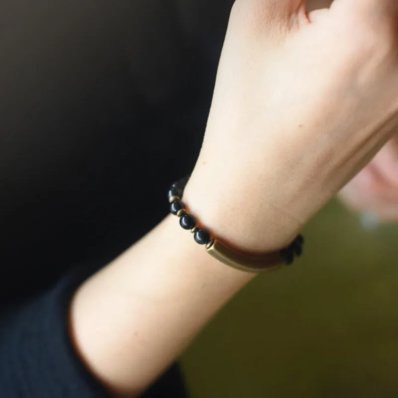 Layered retro ethnic bracelet for men and women with stone beads and brass accents on a wrist.