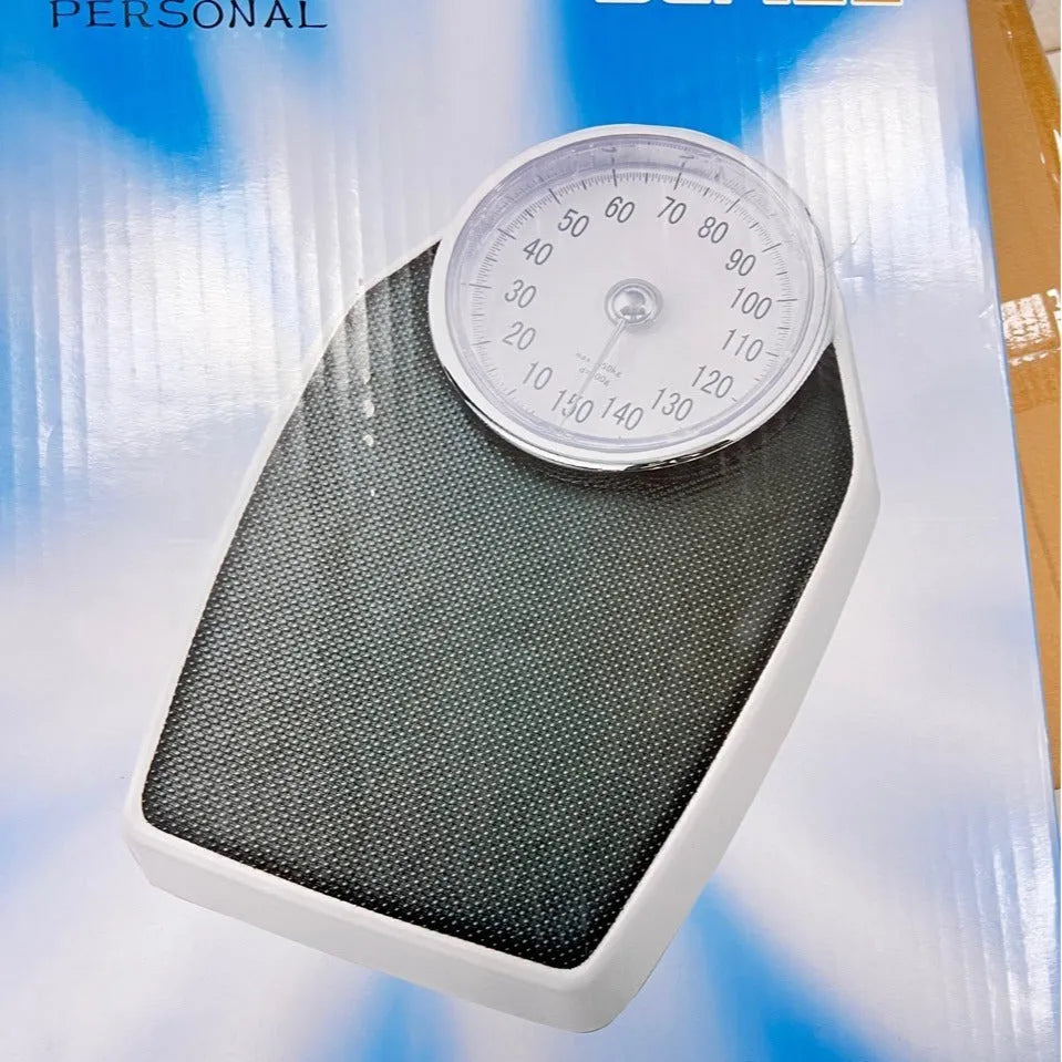 Black mechanical bathroom scale with large analogue dial showing weight measurements