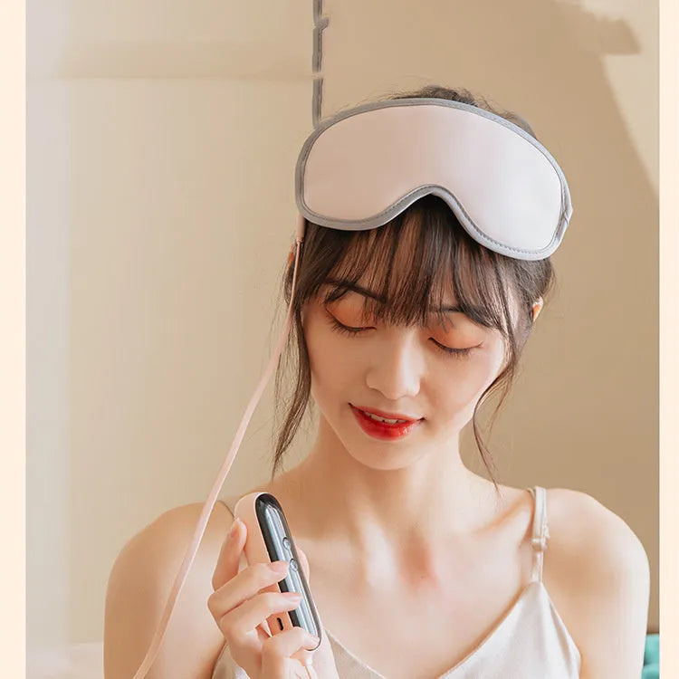 Pink and green portable USB steam sleep massage goggles on a table