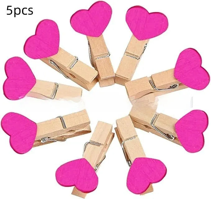 Set of five small wooden heart-shaped hair clips in various colours on a neutral background.