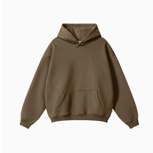 Man wearing a grey heavyweight cotton terry hooded sweater with a loose fit and drop-shoulder sleeves.