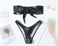 Black women's one-piece swimsuit with colourful bikini print and backless design