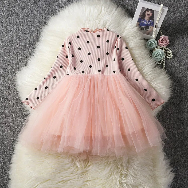 Baby girl wearing a long sleeve white lace tutu dress for a birthday or christening.