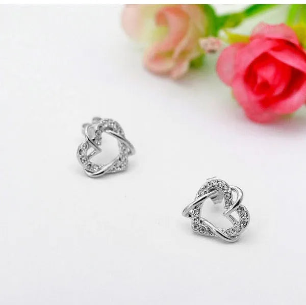 Gold colour alloy heart-shaped stud earrings on white background