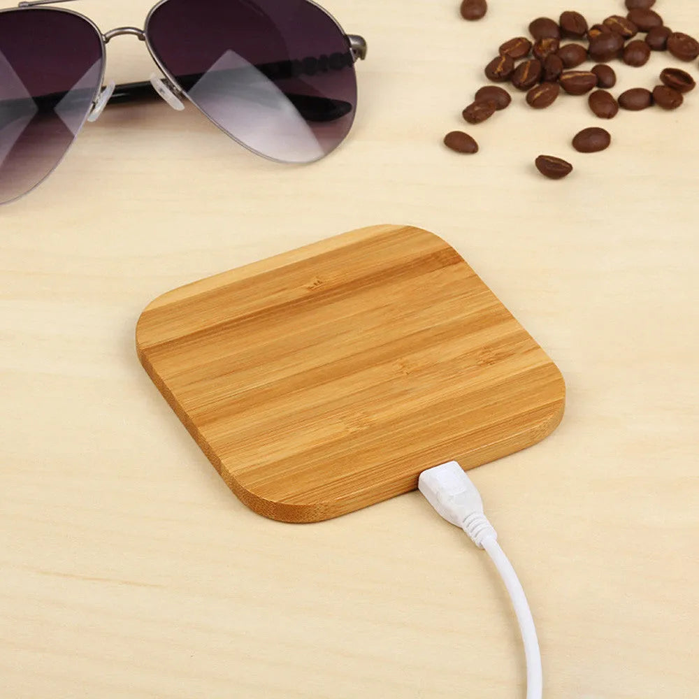 Brown wooden bamboo square 5W wireless charging pad on a desk.
