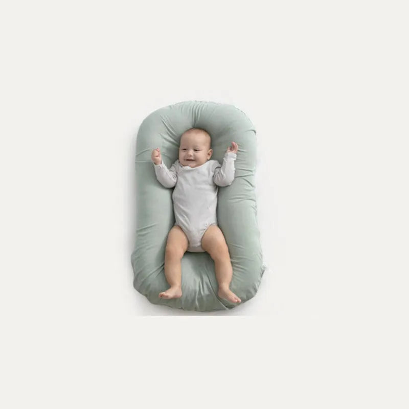 Beige portable baby nest crib for newborns measuring 75cm by 45cm on a neutral background.
