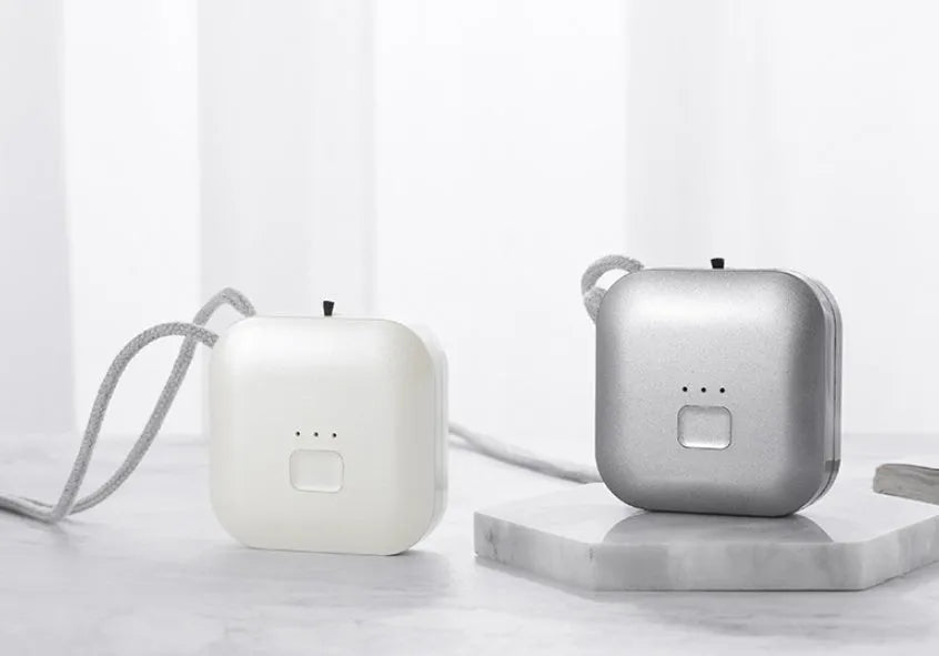Mini USB portable air purifier necklace worn as a collar, showing pink and blue colour options.