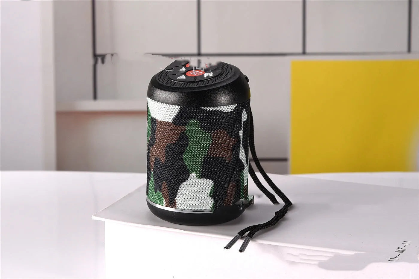 Portable outdoor Bluetooth subwoofer in multiple colours showing button controls for radio and playback functions.