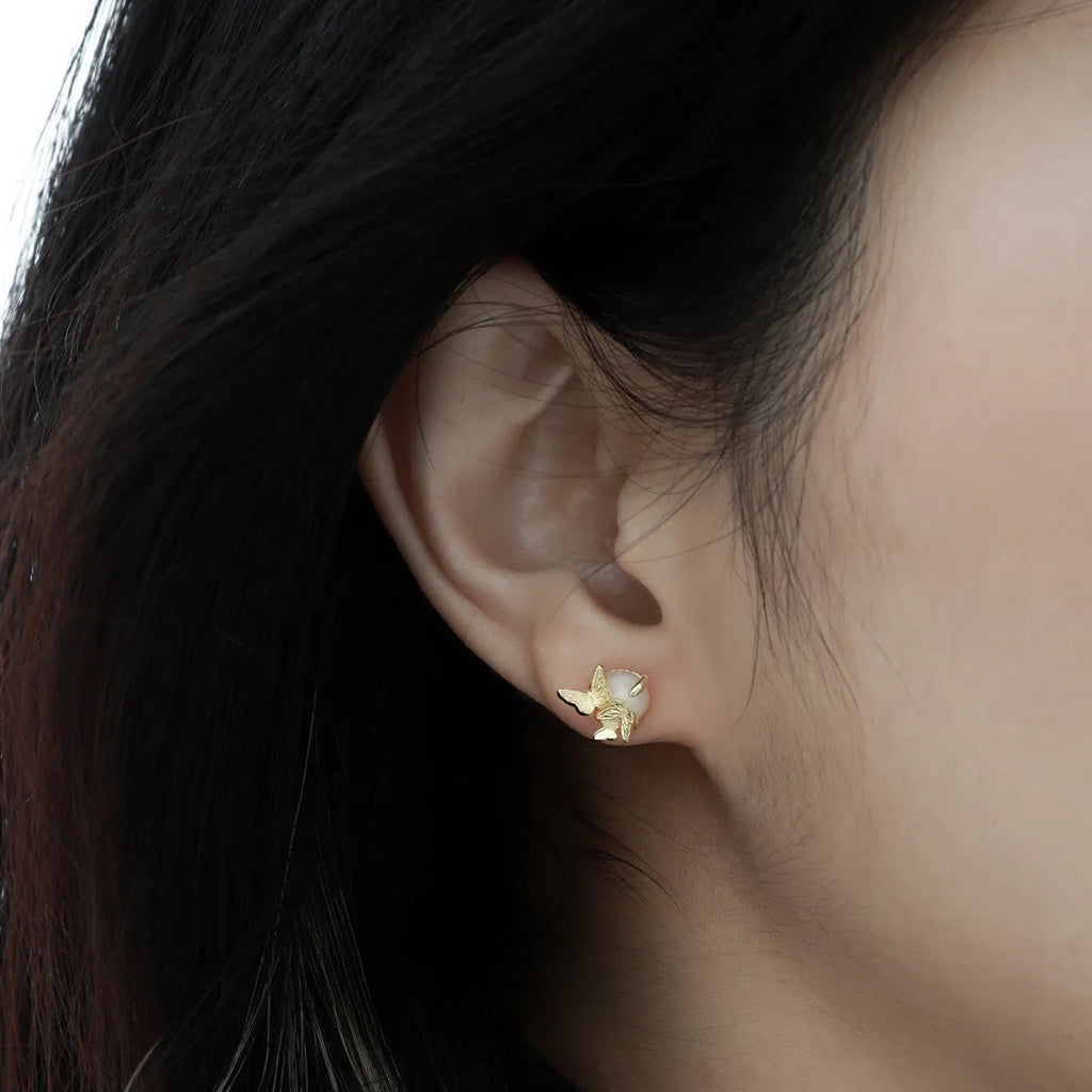A pair of 925 silver butterfly ear studs with an original animal design, shown in gold and white gold colour finishes.