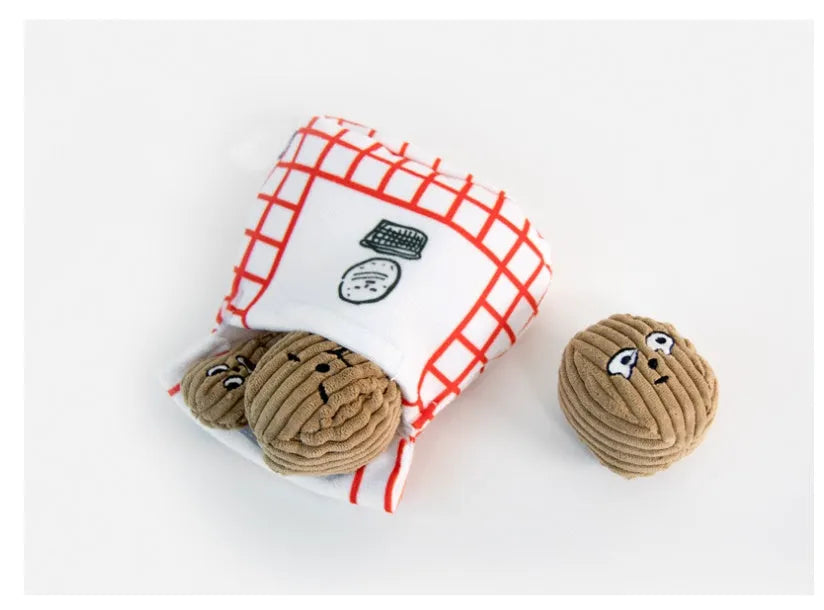 Hidden food toy set for dogs with two walnut toys, one peanut toy, and a rustling paper snack bag on a table