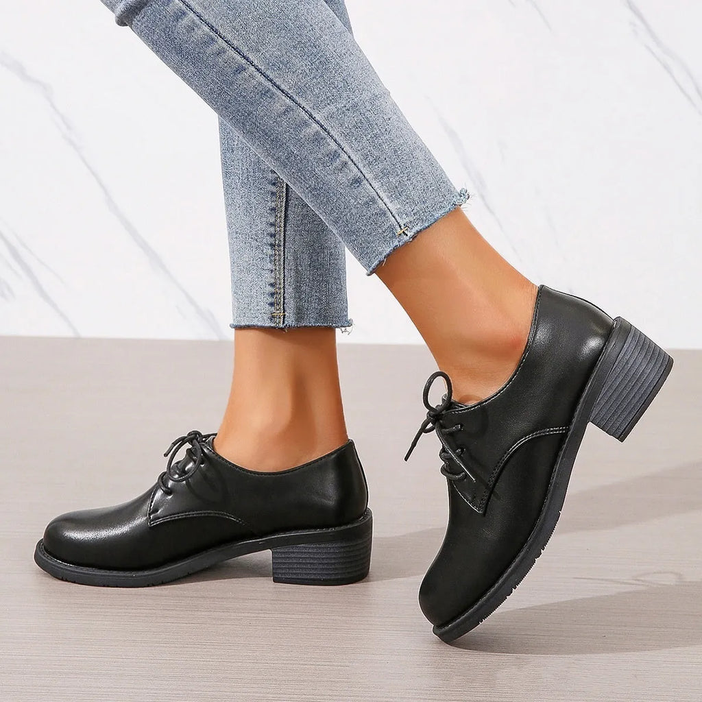 Black women's low-top work shoes with a chunky heel, rounded toe, and soft rubber sole.