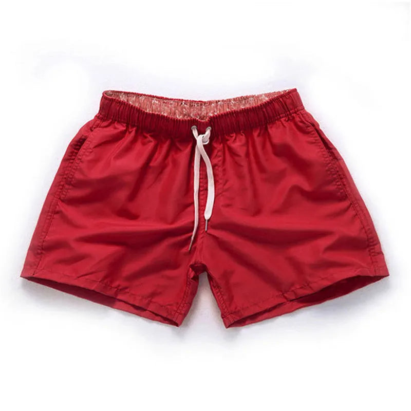 Men's straight-leg beach shorts in polyester fabric on a beach background