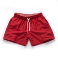 Men's straight-leg beach shorts in polyester fabric on a beach background