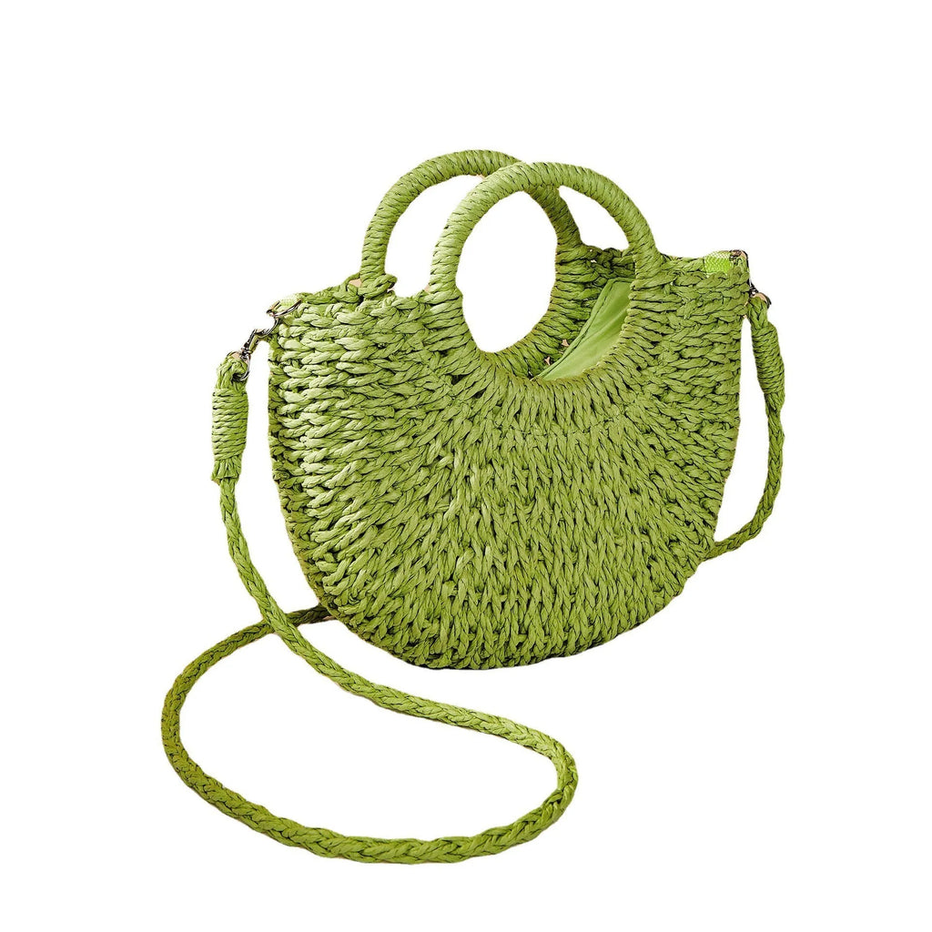 Woven straw beach bag in beige, peach skin lining, crossbody style, 24cm height, on a sandy beach