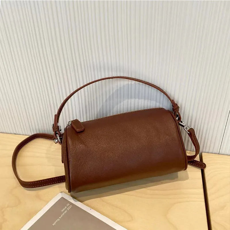 Soft brown genuine leather cylindrical crossbody phone bag with adjustable strap.