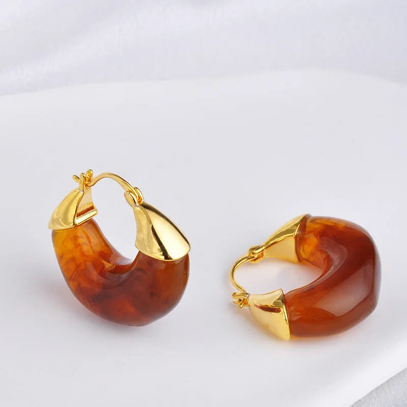 Copper geometry shape retro Maillard style earrings with electroplated finish in amber colour option on plain background