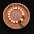 Carved Bodhi root bracelet with white jade, lotus, and pumpkin beads in various sizes.