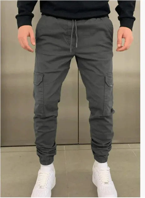 Men's casual straight-leg trousers with patch pockets in polyester fabric, available in seven colours with elastic waistband
