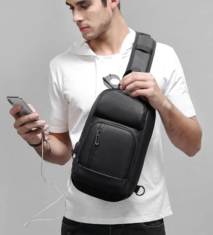 Black PVC outdoor leisure shoulder bag showing air cushion strap and organisational pockets
