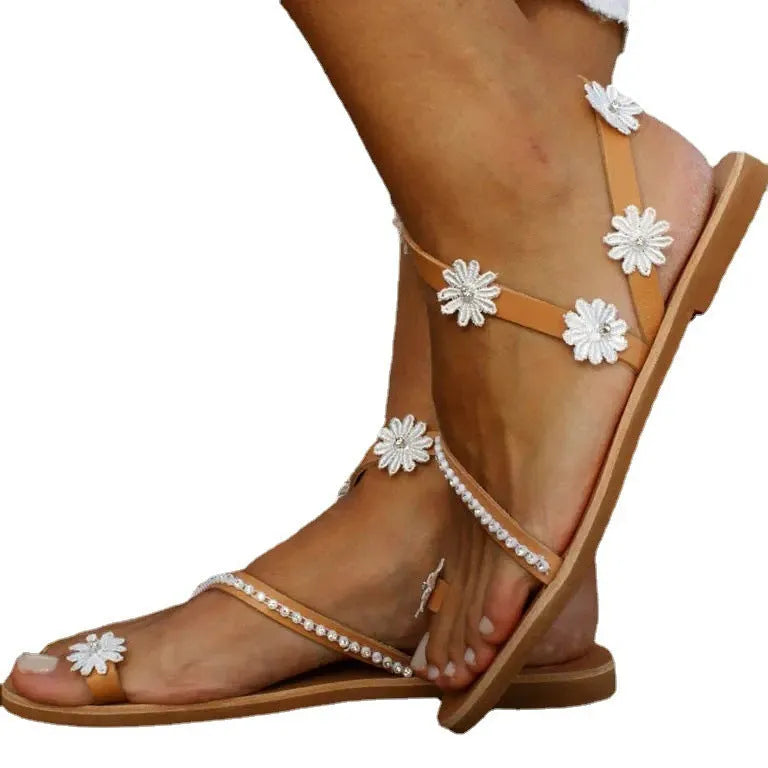 Brown women's Roman sandals with flower detail and herringbone toe design on flat rubber sole
