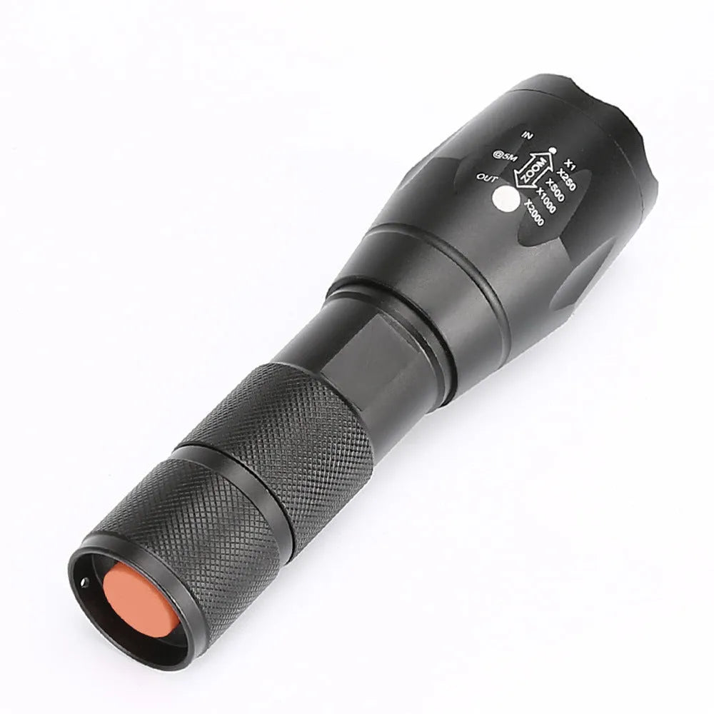 Black aluminum alloy zoom flashlight with adjustable head for focus, shown with beam reaching into distance.