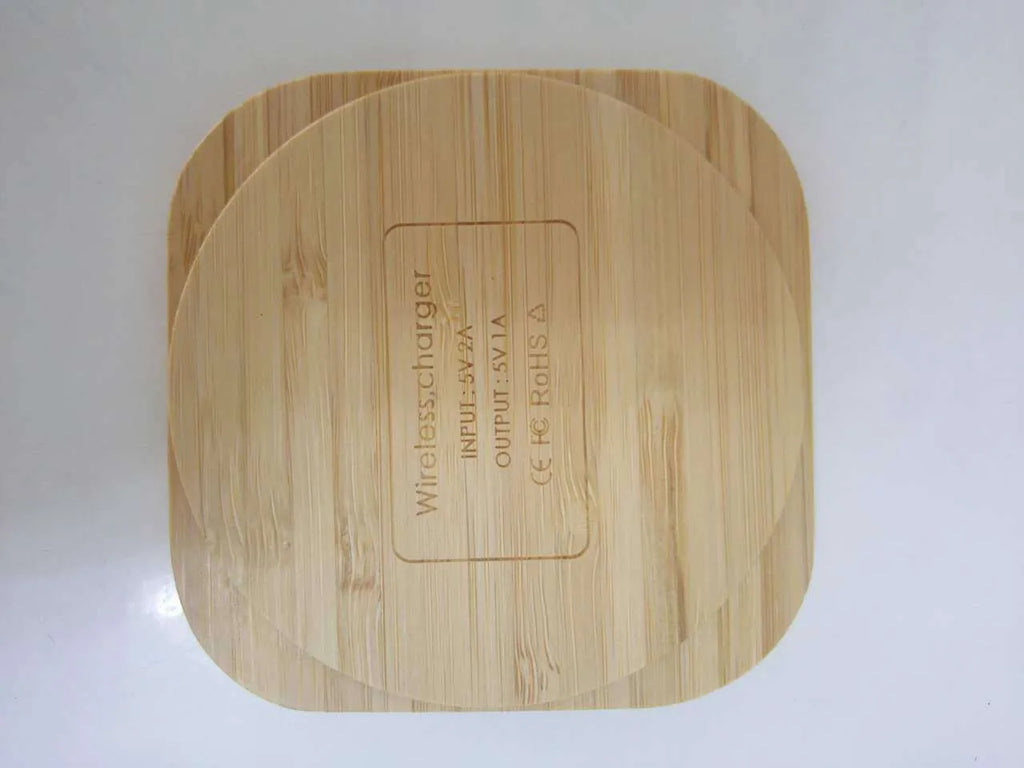 Brown wooden bamboo square 5W wireless charging pad on a desk.