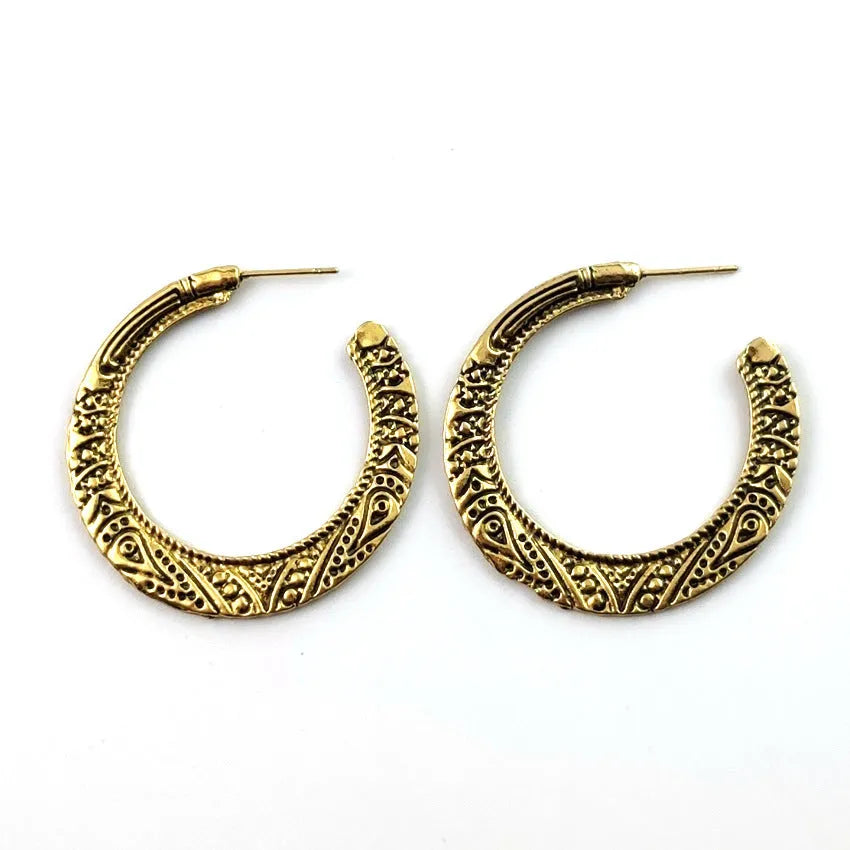 A pair of vintage-style C-shaped alloy earrings with detailed street shot engraving, shown in bronze finish.