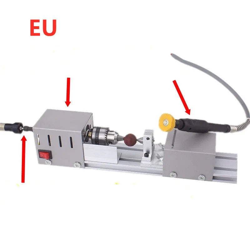 Mini metal woodworking lathe with silver finish and carving accessories on workbench