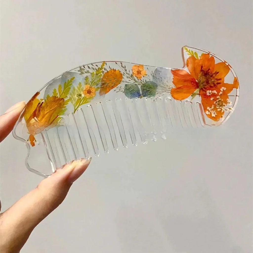 Small glossy resin hair comb with a reflective mirror finish, shown in one of three colour options.
