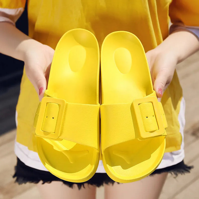 Women's grey blue buckle flip flops with a soft EVA sole on a plain background