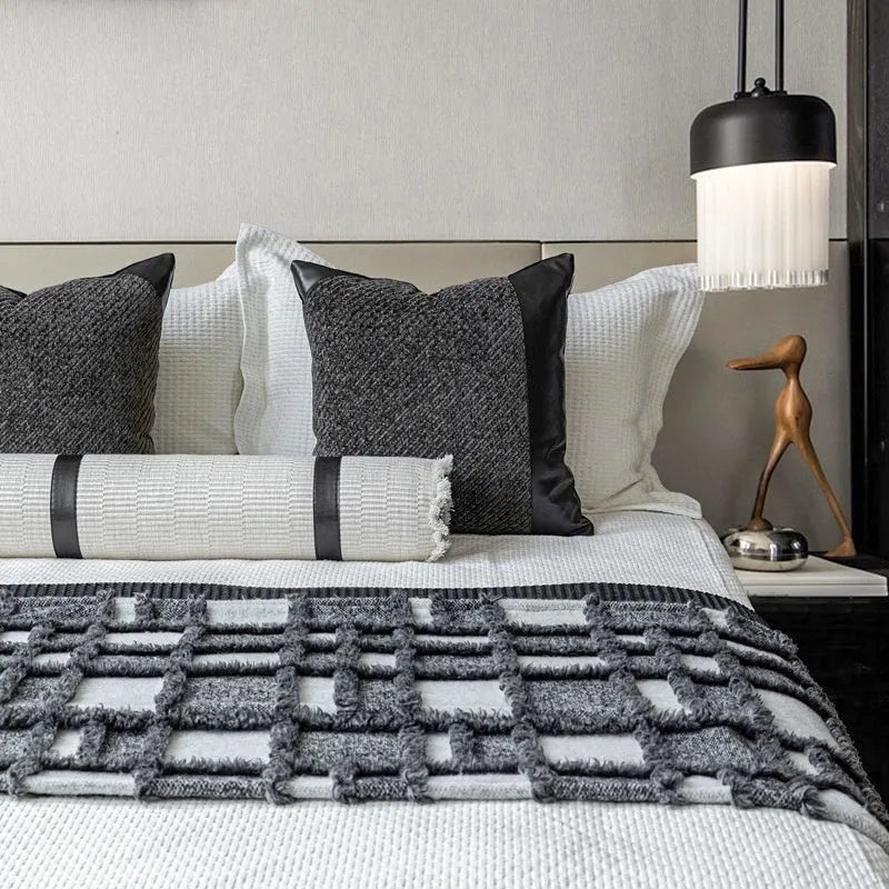 Grey and white plaid bed runner blanket and matching pillow on a double bed.